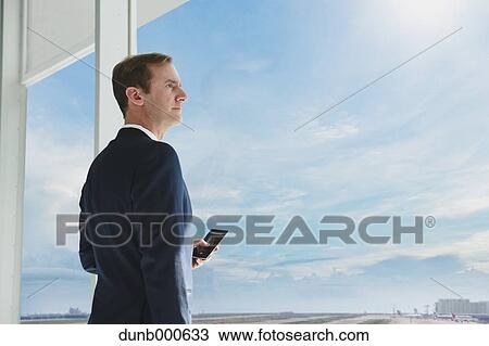 Caucasian businessman with phone in modern office View Large Photo Image Stock Image - Caucasian businessman with phone in modern office. Fotosearch