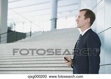 Caucasian businessman with phone in modern office View Large Photo Image Stock Image - Caucasian businessman with phone in modern office. Fotosearch