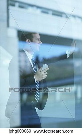 Caucasian businessman with phone in modern office View Large Photo Image Stock Photo - Caucasian businessman with phone in modern office. Fotosearch