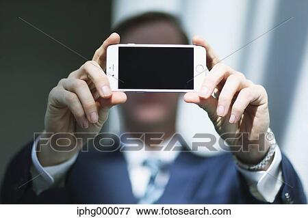 Caucasian businessman with phone in modern office View Large Photo Image Stock Photo - Caucasian businessman with phone in modern office. Fotosearch