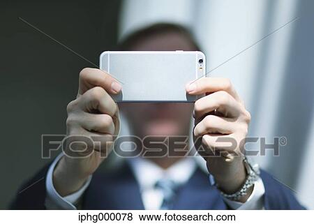 Caucasian businessman with phone in modern office View Large Photo Image Stock Photo - Caucasian businessman with phone in modern office. Fotosearch