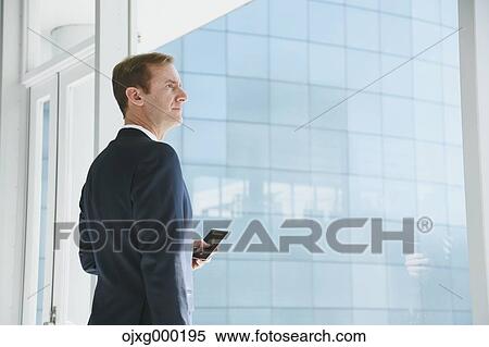Caucasian businessman with phone in modern office View Large Photo Image Stock Photography - Caucasian businessman with phone in modern office. Fotosearch