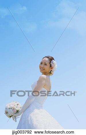 Stock Image - Japanese attractive bride in a city park. Fotosearch
