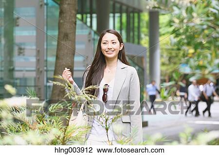 Stock Image - Japanese attractive businesswoman in downtown Tokyo. Fotosearch