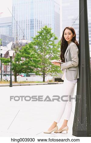 Stock Image - Japanese attractive businesswoman in downtown Tokyo. Fotosearch