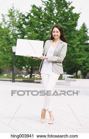 Stock Image - Japanese attractive businesswoman in downtown Tokyo. Fotosearch