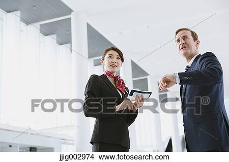 Japanese attractive flight attendant helping customer at the airport View Large Photo Image Picture - Japanese attractive flight attendant helping customer at the airport. Fotosearch