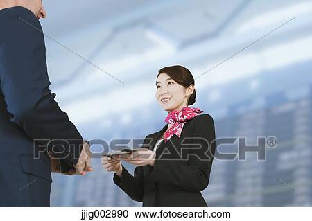 Stock Image - Japanese attractive flight attendant helping customer at the airport. Fotosearch