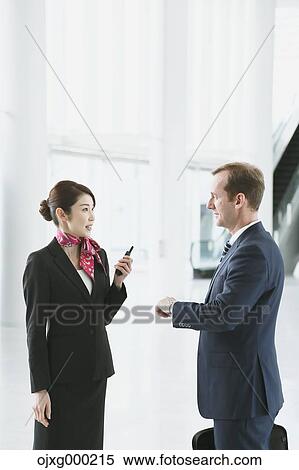 Stock Photography - Japanese attractive flight attendant helping customer at the airport. Fotosearch