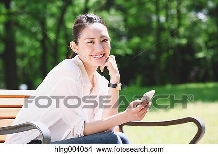 Picture - Japanese attractive woman in a city park. Fotosearch