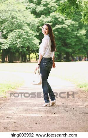 Stock Image - Japanese attractive woman in a city park. Fotosearch