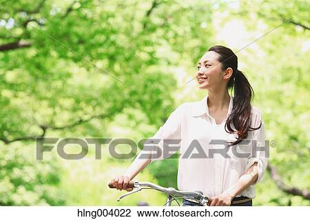 Stock Image - Japanese attractive woman in a city park. Fotosearch