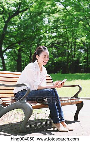 Stock Image - Japanese attractive woman in a city park. Fotosearch