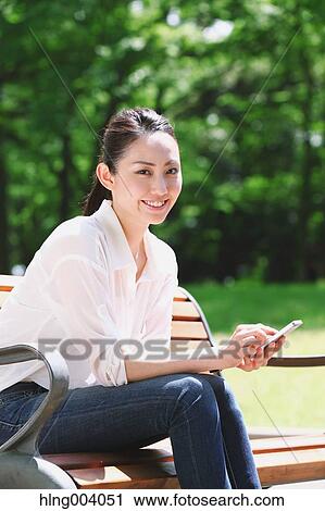 Stock Image - Japanese attractive woman in a city park. Fotosearch