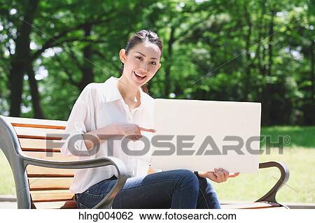 Stock Image - Japanese attractive woman in a city park. Fotosearch