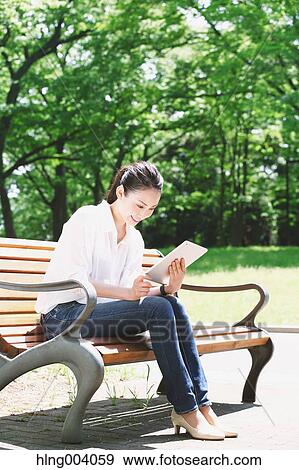 Stock Photo - Japanese attractive woman in a city park. Fotosearch