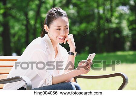 Stock Photograph - Japanese attractive woman in a city park. Fotosearch