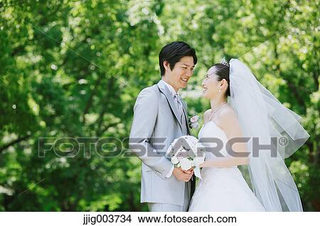 Picture - Japanese bride and groom in a city park. Fotosearch