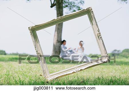 Stock Image - Japanese bride and groom in a city park. Fotosearch