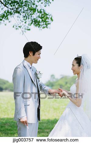 Stock Photo - Japanese bride and groom in a city park. Fotosearch