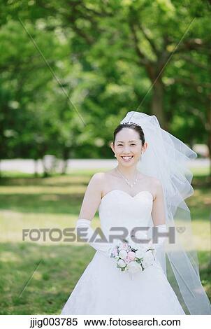 Stock Photography - Japanese bride and groom in a city park. Fotosearch
