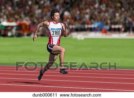 Stock Image - Japanese male sprinter running on track. Fotosearch