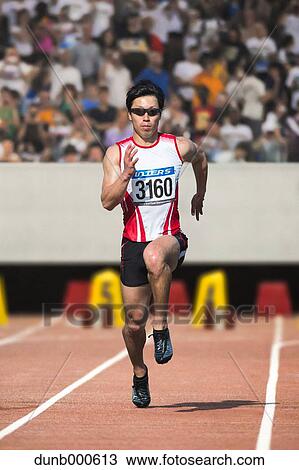 Stock Image - Japanese male sprinter running on track. Fotosearch