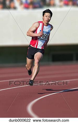 Stock Image - Japanese male sprinter running on track. Fotosearch