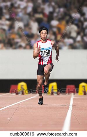 Stock Photograph - Japanese male sprinter running on track. Fotosearch