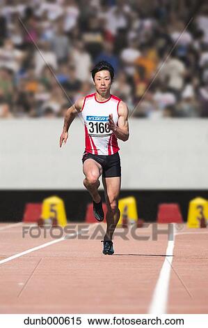 Stock Photography - Japanese male sprinter running on track. Fotosearch