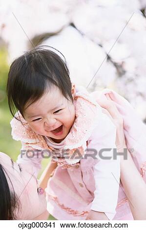 Japanese mom and daughter enjoying the cherry blossoms View Large Photo Image Stock Image - Japanese mom and daughter enjoying the cherry blossoms. Fotosearch