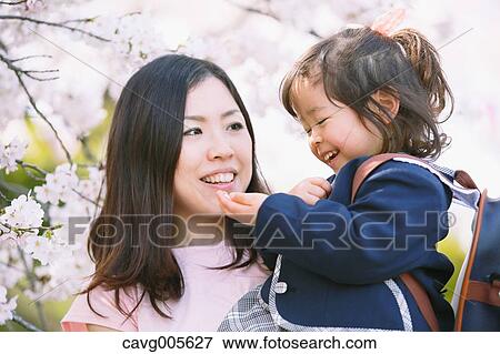 Japanese mom and daughter enjoying the cherry blossoms View Large Photo Image Stock Photo - Japanese mom and daughter enjoying the cherry blossoms. Fotosearch