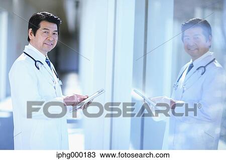 Stock Image - Japanese senior doctor at the hospital. Fotosearch