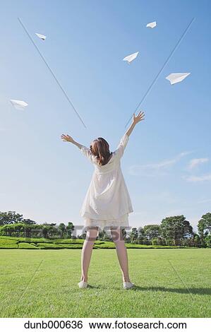 Japanese woman flying paper planes in a city park View Large Photo Image Stock Photograph - Japanese woman flying paper planes in a city park. Fotosearch