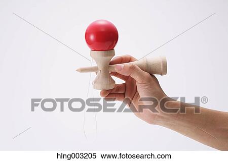Stock Photography - Man playing with Japanese traditional Kendama game. Fotosearch