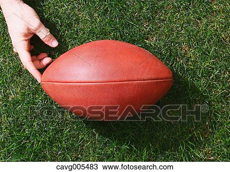 Man with American football ball on grass View Large Photo Image Stock Image - Man with American football ball on grass. Fotosearch