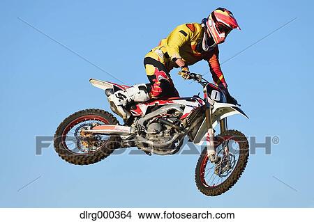 Motocross biker jumping over dirt track View Large Photo Image Picture - Motocross biker jumping over dirt track. Fotosearch