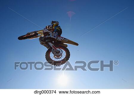 Motocross biker jumping over dirt track View Large Photo Image Picture - Motocross biker jumping over dirt track. Fotosearch