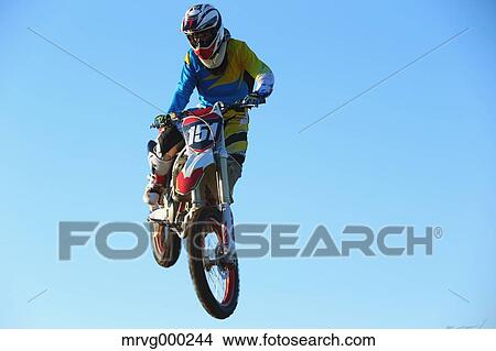 Motocross biker jumping over dirt track View Large Photo Image Picture - Motocross biker jumping over dirt track. Fotosearch