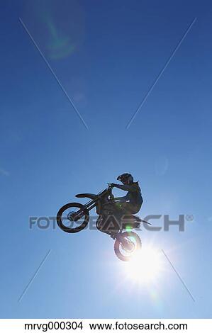 Motocross biker jumping over dirt track View Large Photo Image Picture - Motocross biker jumping over dirt track. Fotosearch