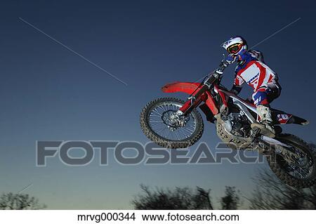 Motocross biker jumping over dirt track View Large Photo Image Picture - Motocross biker jumping over dirt track. Fotosearch