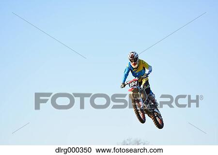 Motocross biker jumping over dirt track View Large Photo Image Stock Image - Motocross biker jumping over dirt track. Fotosearch