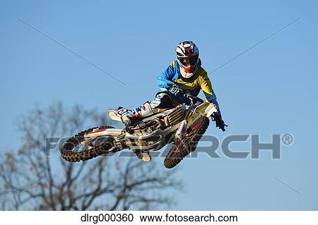 Motocross biker jumping over dirt track View Large Photo Image Stock Image - Motocross biker jumping over dirt track. Fotosearch