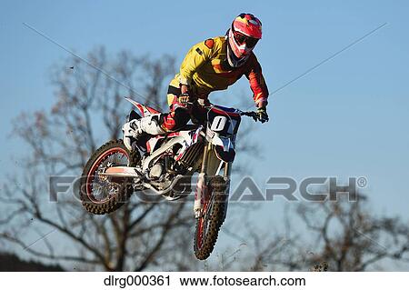 Motocross biker jumping over dirt track View Large Photo Image Stock Image - Motocross biker jumping over dirt track. Fotosearch