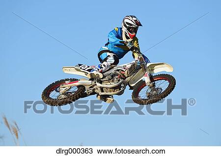 Motocross biker jumping over dirt track View Large Photo Image Stock Image - Motocross biker jumping over dirt track. Fotosearch
