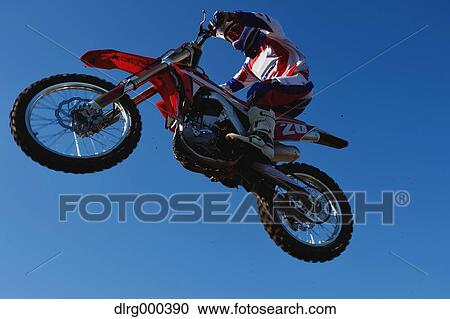 Motocross biker jumping over dirt track View Large Photo Image Stock Image - Motocross biker jumping over dirt track. Fotosearch