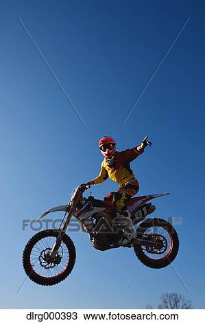 Motocross biker jumping over dirt track View Large Photo Image Stock Image - Motocross biker jumping over dirt track. Fotosearch