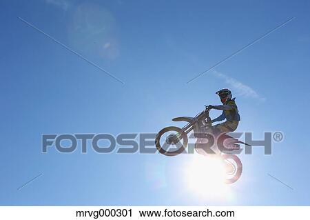Motocross biker jumping over dirt track View Large Photo Image Stock Image - Motocross biker jumping over dirt track. Fotosearch
