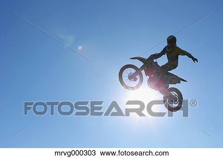 Motocross biker jumping over dirt track View Large Photo Image Stock Image - Motocross biker jumping over dirt track. Fotosearch