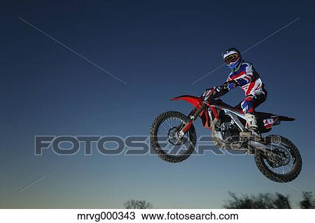 Motocross biker jumping over dirt track View Large Photo Image Stock Image - Motocross biker jumping over dirt track. Fotosearch